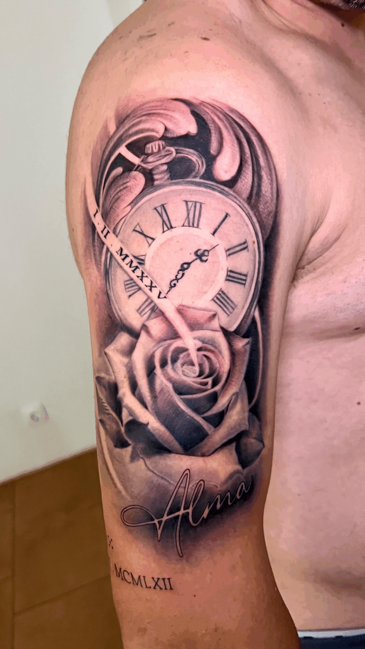 Tatuaje en brazo de reloj antiguo con rosa y nombre personalizado en estilo realista