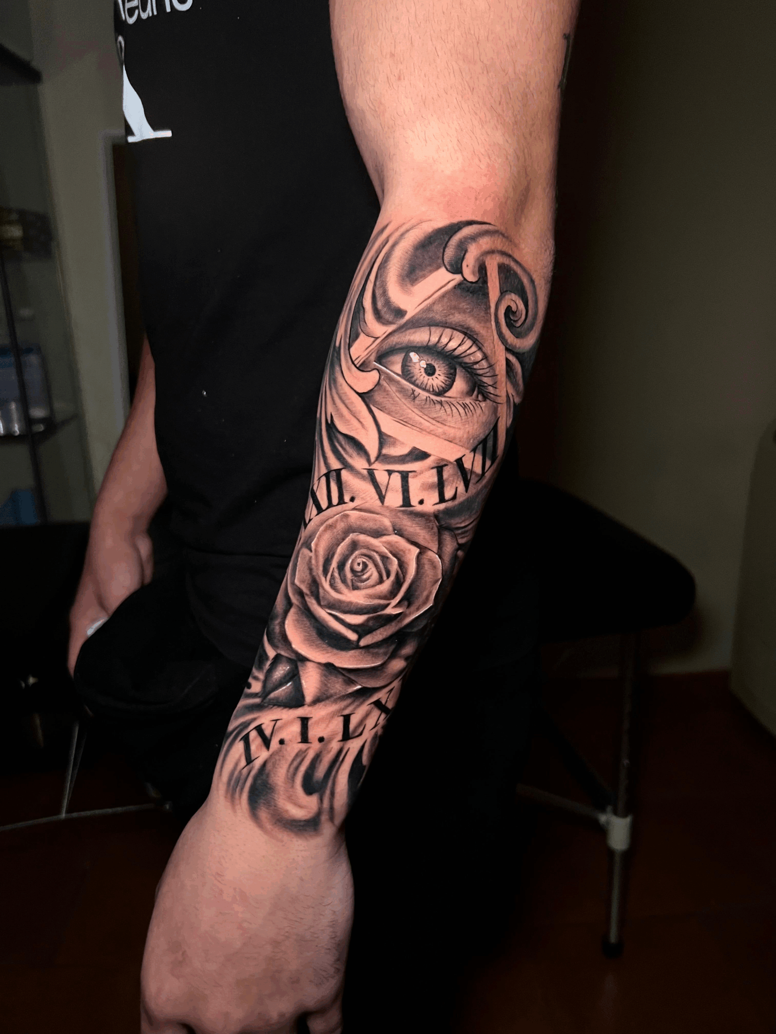 Tatuaje en antebrazo de ojo con números romanos VI-LEN y rosa estilo realista