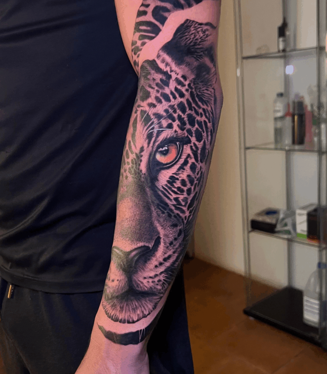 Tatuaje de manga completa en brazo con diseños tribales y motivos decorativos en negro